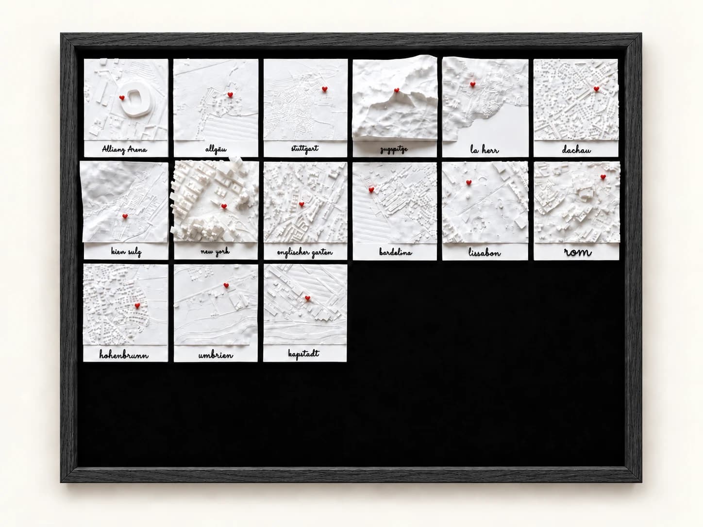 Kalender im Rahmen Schwarz mit 15 beschrifteten Ortskacheln und freiem Platz für neun weitere.